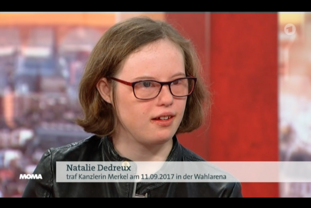 Natalie Dedreux auf dem Fernsehbildschirm. Eine Bauchbinde mit ihrem Namen wird eingeblendet.