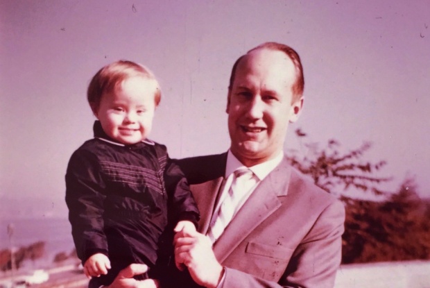 Ein Mann mit Down-Syndrom mit seinem Kind auf dem Arm, Foto: privat