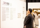 2 Personen lesen die Wandtexte in der Ausstellung. Sie sind zweisprachig in Ukrainisch und Englisch an den Wänden zu sehen.